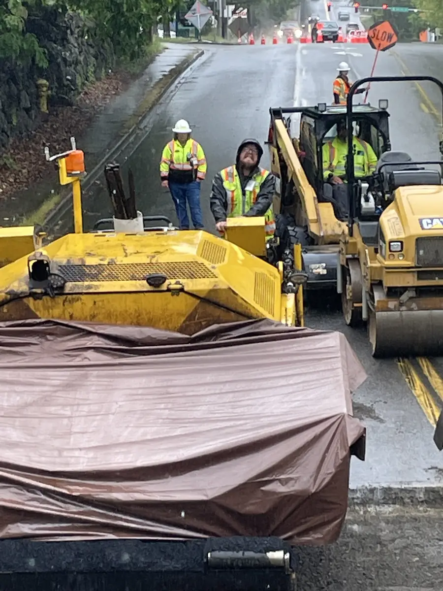 Paver and crew laying asphalt on a street