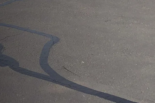 Asphalt pavement with freshly applied black rubberized crack sealant tracing the cracks