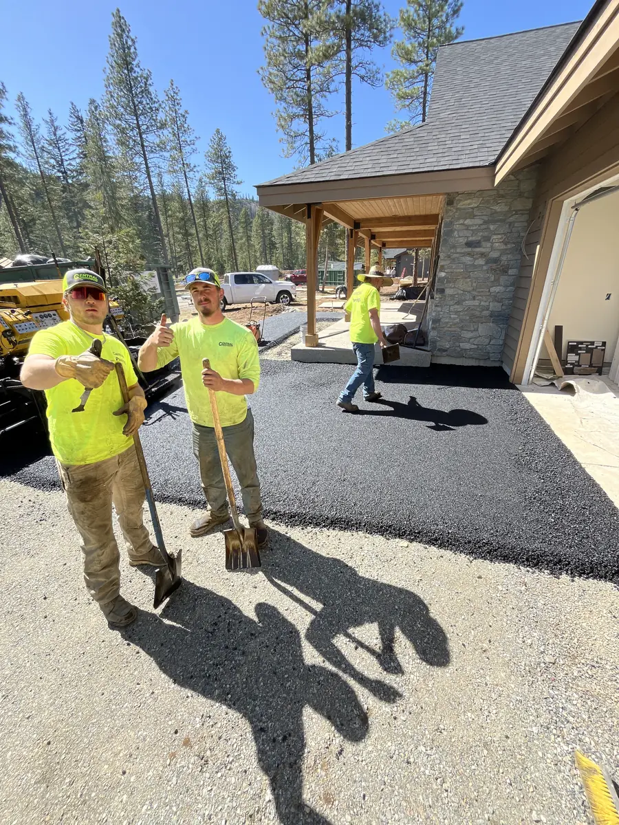 Crew members standing on a new asphalt driveway at a new home