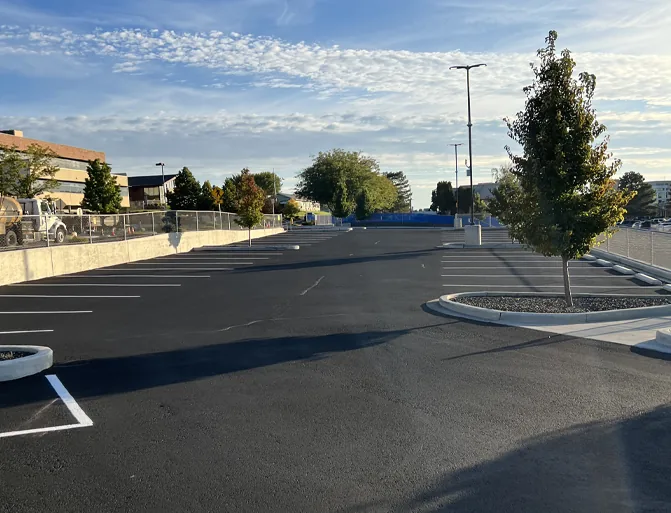 Large newly paved parking lot with fresh black asphalt and landscaped islands
